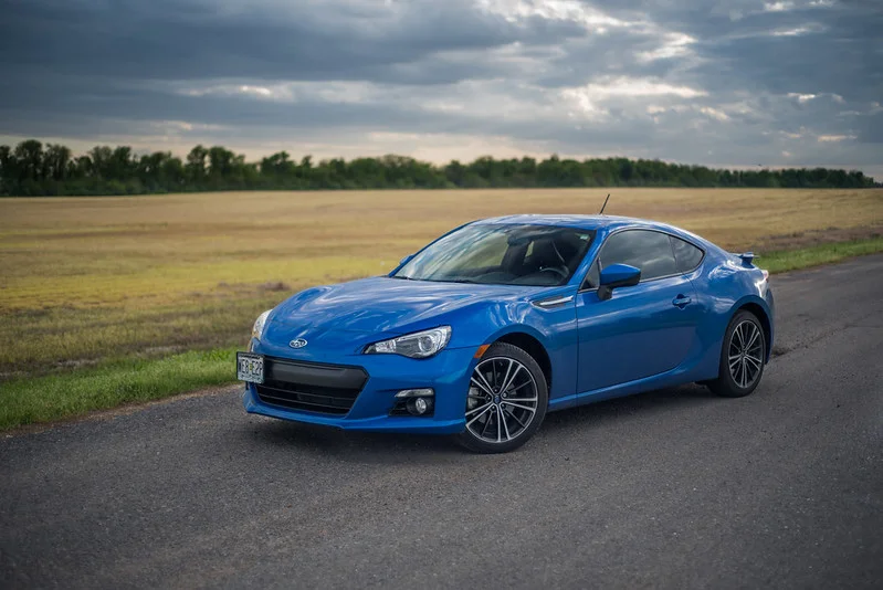 Blue Subaru BRZ near a field